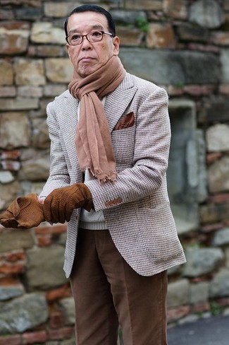 Сочетание белого вязаного свитера и темно-коричневых брюк чинос позволит создать образ в классическом мужском стиле.