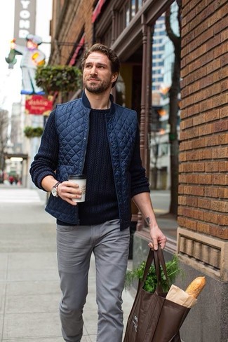 Темно-сине-белый вязаный свитер и серые джинсы — необходимые вещи в гардеробе любителей стиля casual.