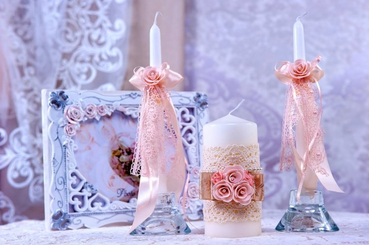 Белые свадебные свечи с розовой отделкой лентами и бутонами
