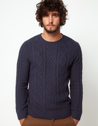 Темно-сине-белый вязаный свитер и коричневые брюки чинос — беспроигрышный вариант непринужденного повседневного лука.