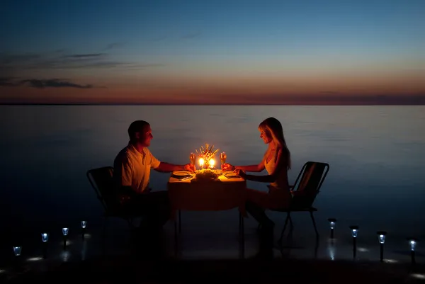 Молодая пара поделиться романтического ужина при свечах на пляже — стоковое фото