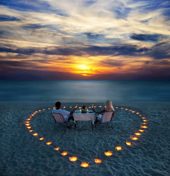 Молодая пара разделяет романтический ужин на пляже — стоковое фото