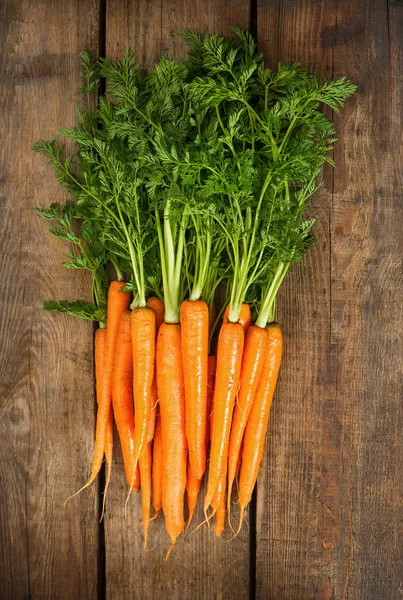 Свежие морковь с зелеными листьями на деревянные — стоковое фото