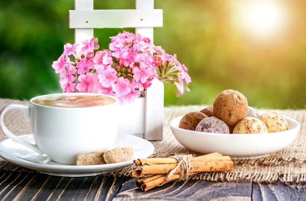 Чашка кофе, цветы, шоколад и конфеты — стоковое фото