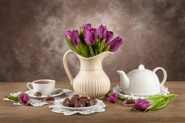 Тюльпаны в вазе, чай, шоколад на борту — стоковое фото