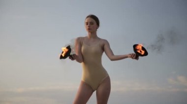 Молодая красивая женщина танцует с огнем носить костюм тела на восход солнца в пустыне — стоковое видео