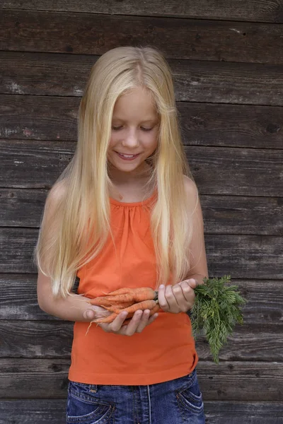 Девушка с букетом из моркови — стоковое фото