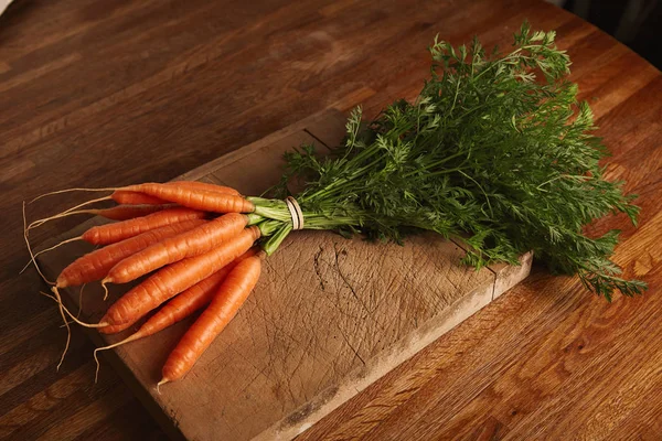 Букет из моркови на старую доску — стоковое фото