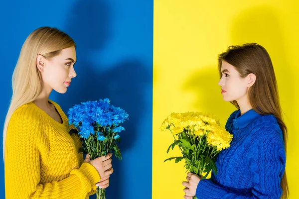 Female Fashion Models Holding Chrysanthemum Bouquets Looking Each Other Blue — стоковое фото